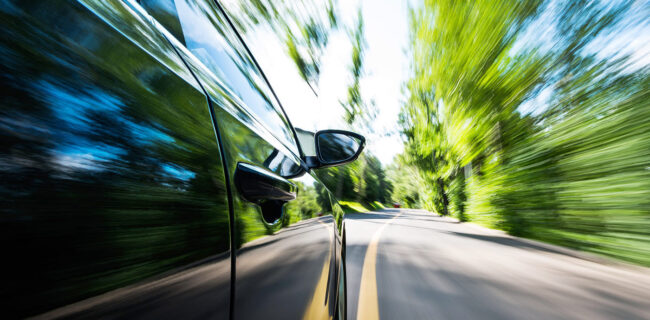 AdobeStock_503758104 Speeding car down a country lane